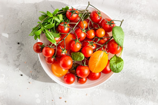 Rote Kirsche und gelbe Tomaten mit Babyspinat