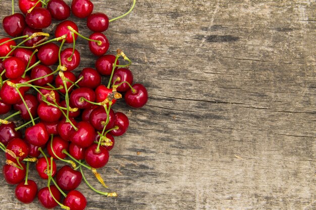 Rote Kirschfrüchte auf hölzernem Hintergrund. Draufsicht mit Kopienraum