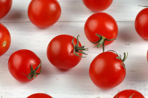 Rote Kirschtomate auf einem weißen Tisch Hintergrund oder Textur mit Tomaten