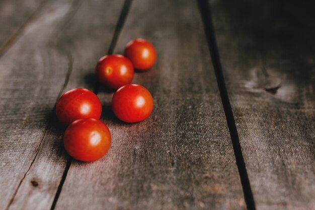 Rote Kirschtomaten auf dem grauen Holztisch.