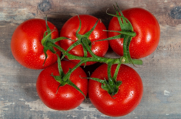 Rote Kirschtomaten auf dem rustikalen Hintergrund