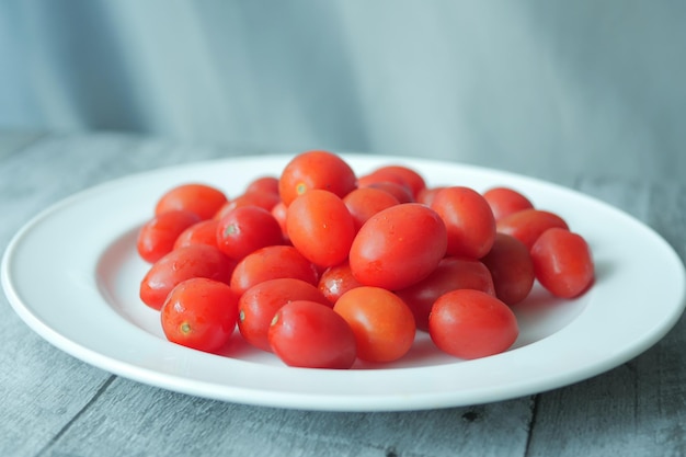 Rote kleine Tomate auf einem Teller auf dem Tisch