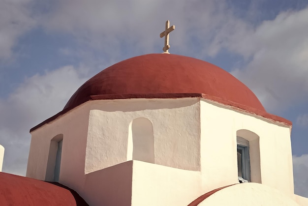 Rote Kuppel mit Kreuz Detail in Mykonos Griechenland Kirchengebäude Architektur auf sonnigen Outdoor-Kapelle am blauen Himmel Religion und Kult-Konzept Sommerurlaub auf der Mittelmeerinsel