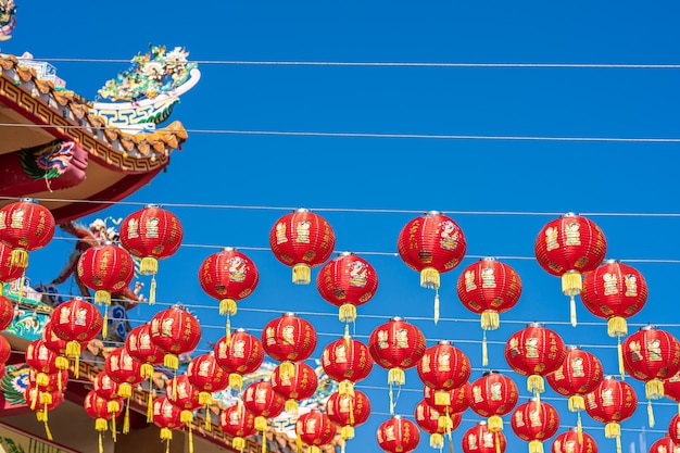 Foto rote laternendekoration für das chinesische neujahrsfest am chinesischen schrein. alte chinesische kunst mit dem chinesischen alphabet. segen darauf geschrieben. ist ein glückssegen-kompliment. ist ein öffentlicher ort in thailand