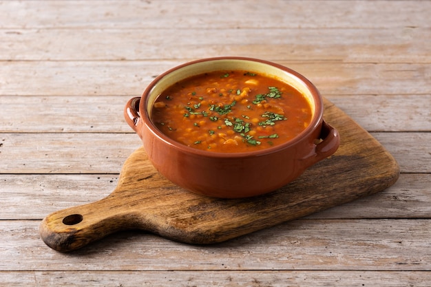 Rote Linsensuppe in Schüssel auf Holztisch