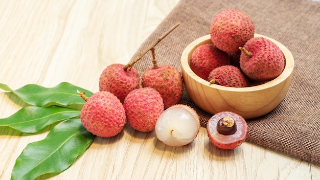 Rote Litschifrucht auf einem Holztisch.