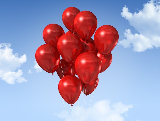 Rote Luftballons schweben auf einem blauen Himmel