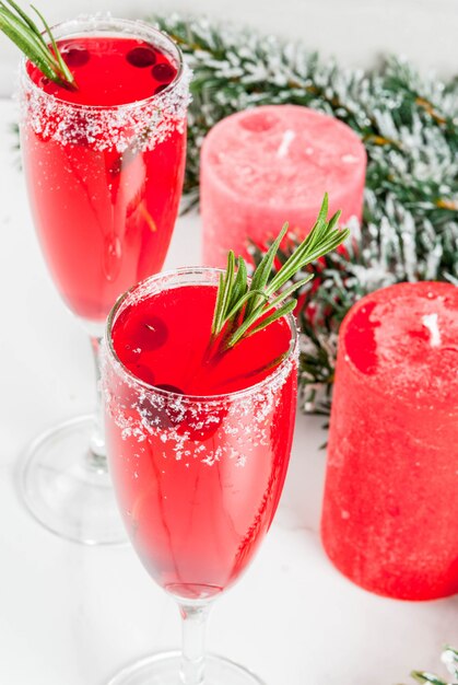 Rote Moosbeermimose des Weihnachtsmorgens mit Rosmarin, weiße Marmorszene mit Weihnachtsdekorationen