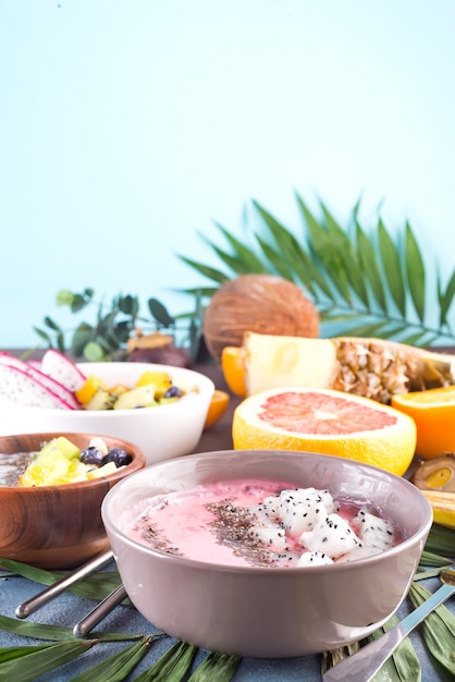 Rote oder rosa Smoothieacai-Schüsseln überstiegen mit frischen pitaya und chia Samen auf Palmblatt auf Steinhintergrund, Kopienraum