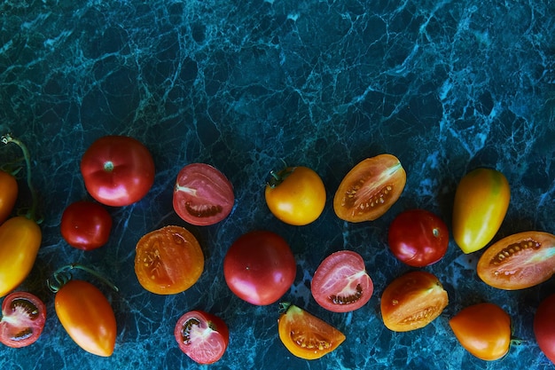 Rote, orange und gelbe Tomaten auf grünem Marmorhintergrund Natürliches organisches Gemüse Kopierbereich Draufsicht Essen