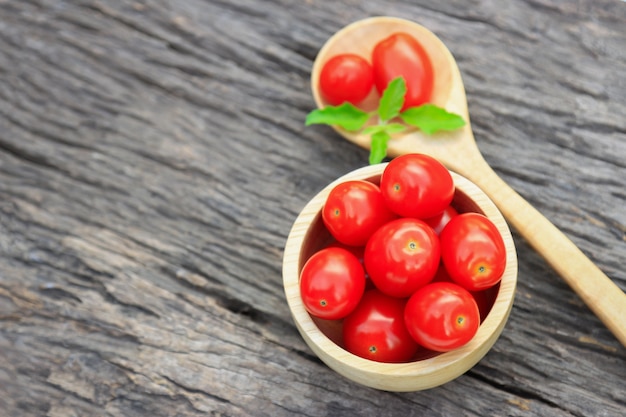 Rote organische kleine Tomate in der hölzernen Schüssel