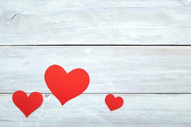 Rote Papierherzen am weißen hölzernen Valentinstag