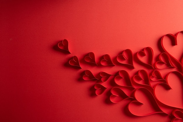 Rote Papierherzen auf rotem Hintergrund. Liebes- und Valentinstagkonzept.