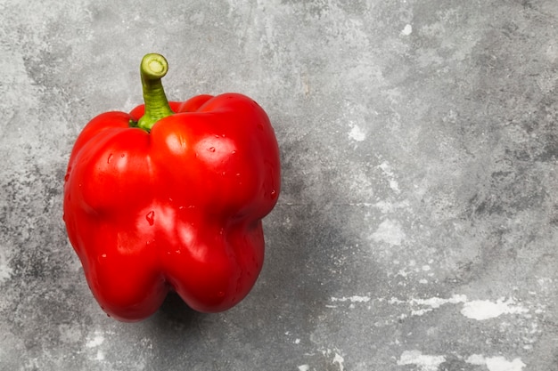 Rote Paprika auf grauem Hintergrund. Draufsicht, Kopierraum. Lebensmittelhintergrund