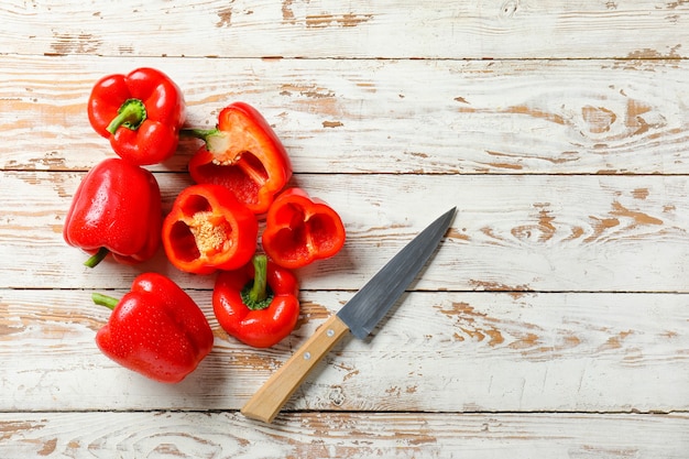 Rote Paprika und Messer auf Holztisch