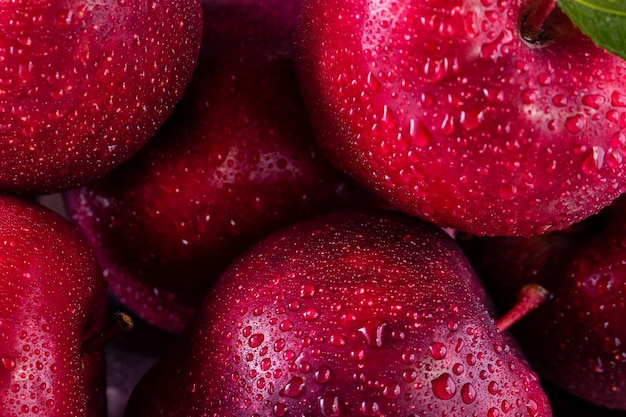 Rote Äpfel mit Blättern auf dem Tisch