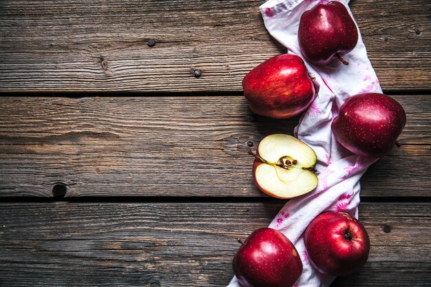 Rote Äpfel und ein Küchentuch auf Holz. Obst, natürliche Nahrung