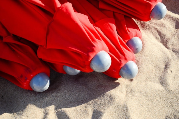 Rote Regenschirme gestapelt auf dem Sand bereit, in einem Gebäude in der Nähe von Punta Del Este Uruguay gelagert zu werden