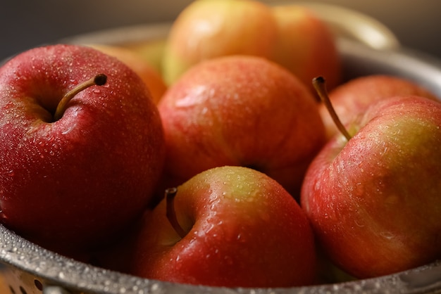 Rote reife Äpfel bedeckt mit Wassertautropfen in der Schüssel nah oben