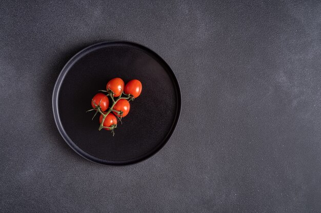 Rote reife Tomaten auf schwarzem Teller