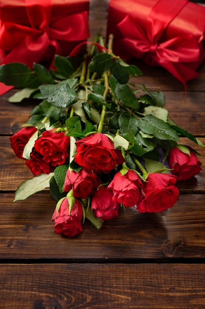 Rote Rosen, Geschenkboxen, linzer Plätzchen auf einem dunklen hölzernen