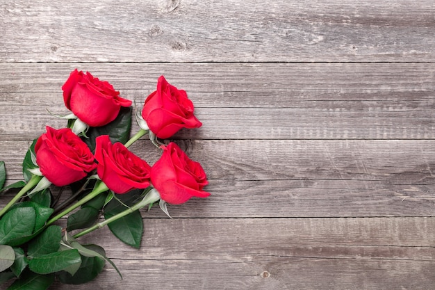 Rote Rosenblumen auf grauem Holztisch. Valentinstag Grußkarte. Draufsicht. Speicherplatz kopieren - Bild