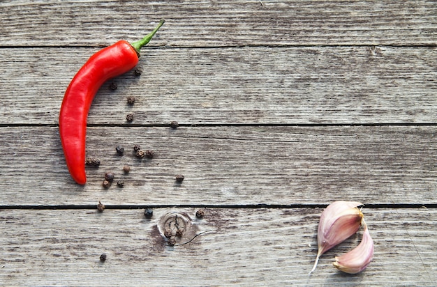 Rote scharfe Chilischoten mit Knoblauch auf Holzuntergrund