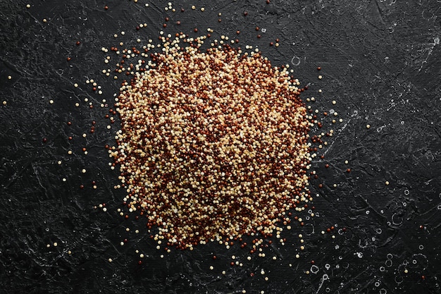 Rote, schwarze und weiße Quinoakörner. Hintergrund für gesunde Lebensmittel. Samen von weißer, roter und schwarzer Quinoa - Chenopodium quinoa