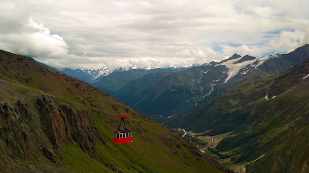 rote Seilbahnkabine vor Bergkulisse