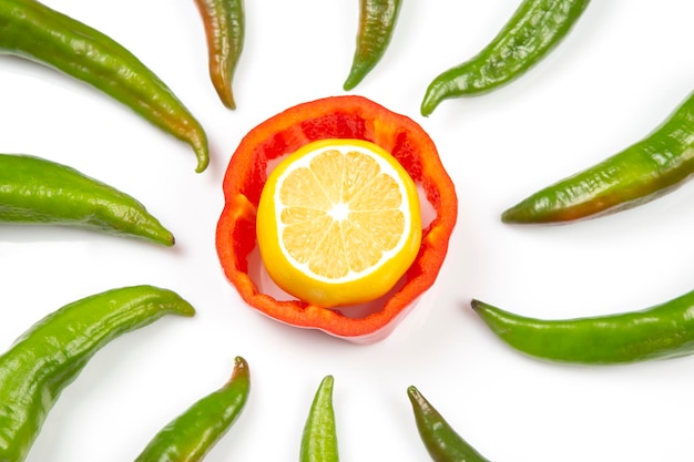 Rote süße und grüne Peperoni und Zitrone auf weißem Hintergrund. Kochen von Gemüse für Lebensmittel