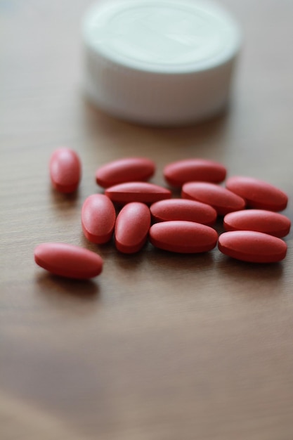 Rote Tabletten mit Vitaminen auf dem Tisch