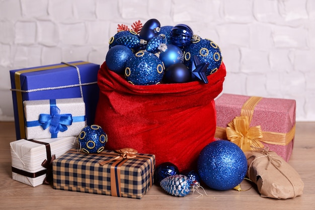 Rote Tasche mit Weihnachtsspielzeug und Geschenken im Zimmer