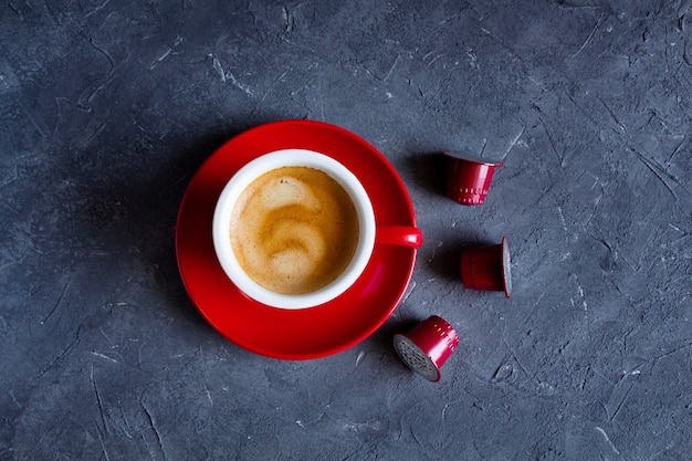 Rote Tasse heißen Cappuccino mit Kaffeekapseln