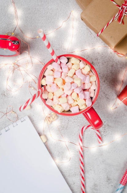 Rote Tasse mit hausgemachtem heißem Kakao und Marshmallows mit Weihnachtsdekoration Konzept gemütlicher Urlaub