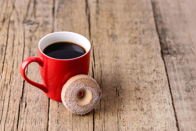 Rote Tasse schwarzen Kaffee und leckere hausgemachte Plätzchen Alter hölzerner Hintergrund kopieren Raum horizontal