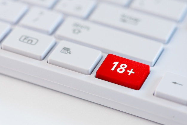 Rote Taste mit 18+ Konzeptsymbol auf Laptop-Tastatur