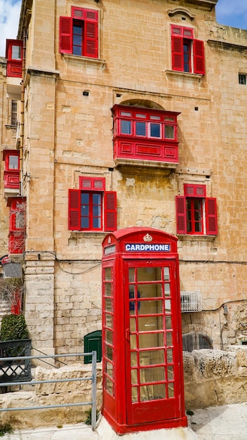 Rote Telefonzelle und alte Balkone in der antiken Stadt Valletta, Malta.