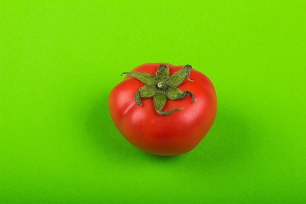 Rote Tomate auf grünem Hintergrund