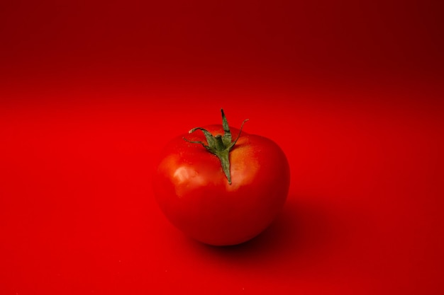 Rote Tomate auf rotem Grund