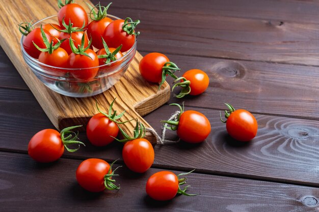 Rote Tomate in Glasschale auf Holztisch Gesunde Bio-Lebensmittel KochzutatenPomodoro auf dem Schreibtisch