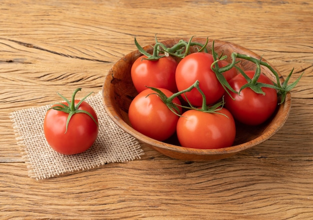 Rote Tomaten in einer Schüssel über Holztisch