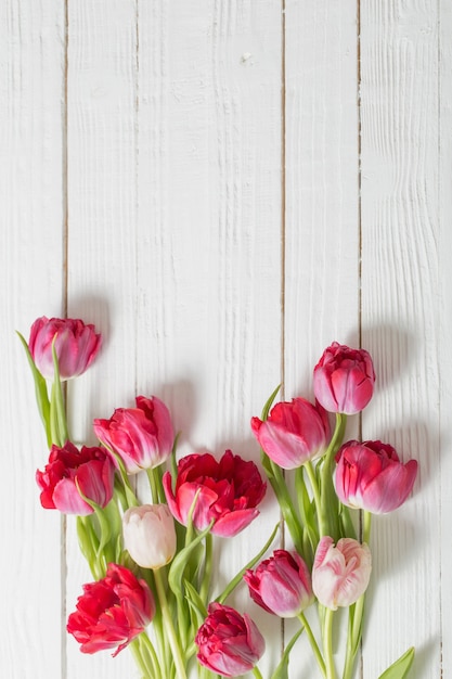 Rote Tulpen auf weißem Holztisch