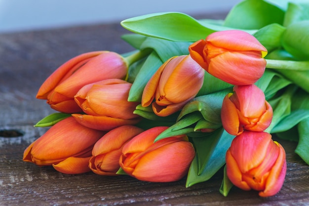 Rote Tulpenblumen auf Hintergrund des hölzernen Brettes.