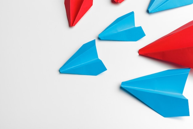 Rote und blaue Papierflugzeuge auf Weiß. Leadership- und Business-Wettbewerb