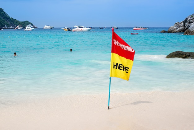 Rote und gelbe Flagge zeigen Mitteilung für das Schwimmen im Meer