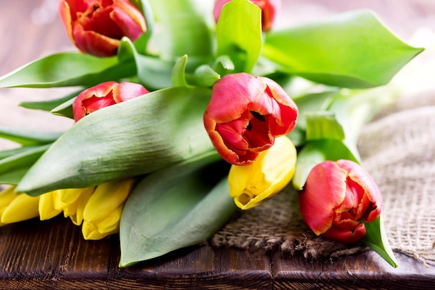 Rote und gelbe Tulpen auf Holzhintergrund Muttertag oder Frauentag Hintergrund