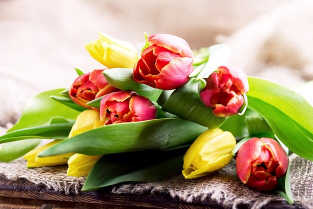 Rote und gelbe Tulpen auf Holzhintergrund Muttertag oder Frauentag Hintergrund