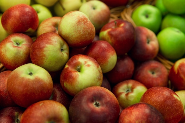 Rote und grüne Äpfel auf der Theke. Helle saftige Früchte. Gesundheit und Vitamine aus der Natur. Nahaufnahme. Selektiver Fokus.