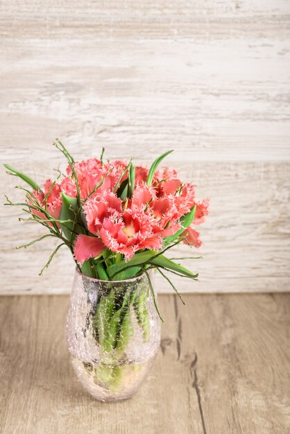 Rote und weiße flaumige Tulpen im Vase auf Holz