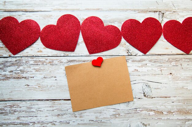 rote Valentinstagherzen mit Karte für Text auf einem hölzernen Hintergrund. Valentinstag. Draufsicht